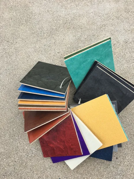 Coating color chips from a fan deck spread across a concrete surface