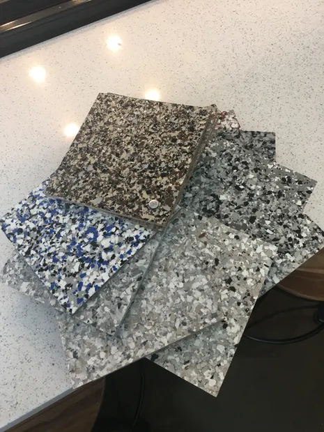 Four flake sample boards in granite tones resting on a polished counter