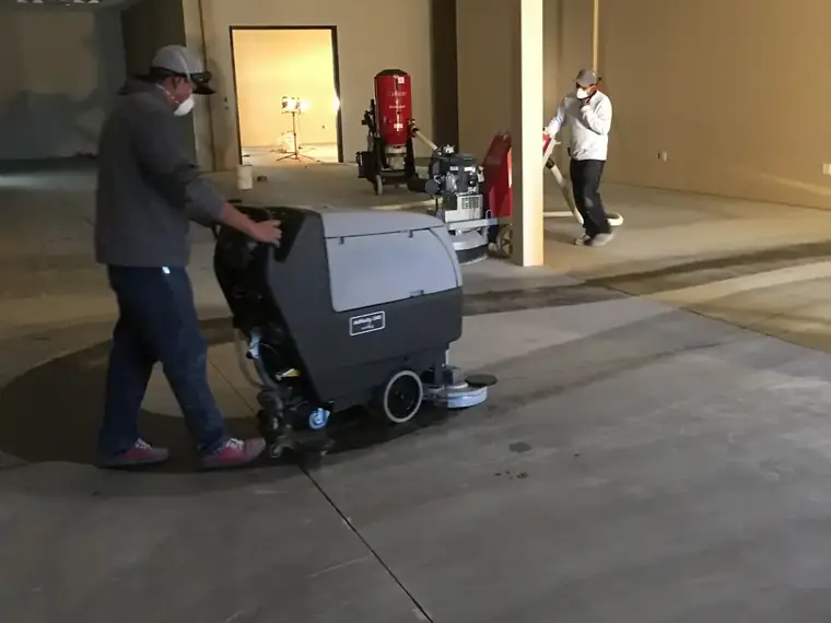 Crew running a floor machine to strip coating from a commercial room