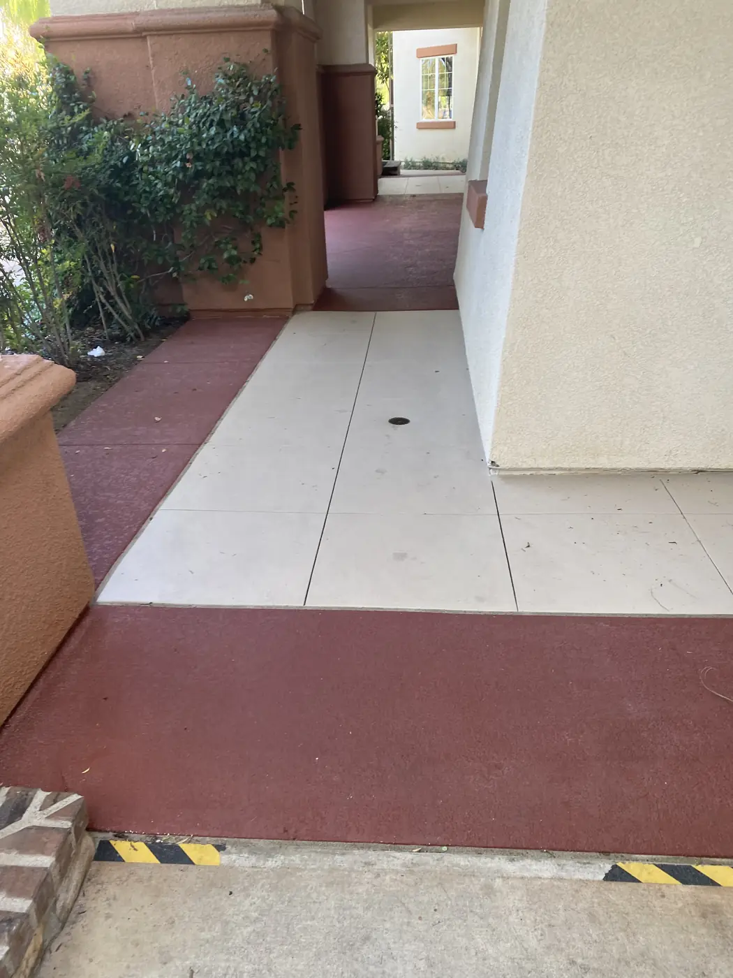 Resurfaced clubhouse walkway in cream with a deep red border band