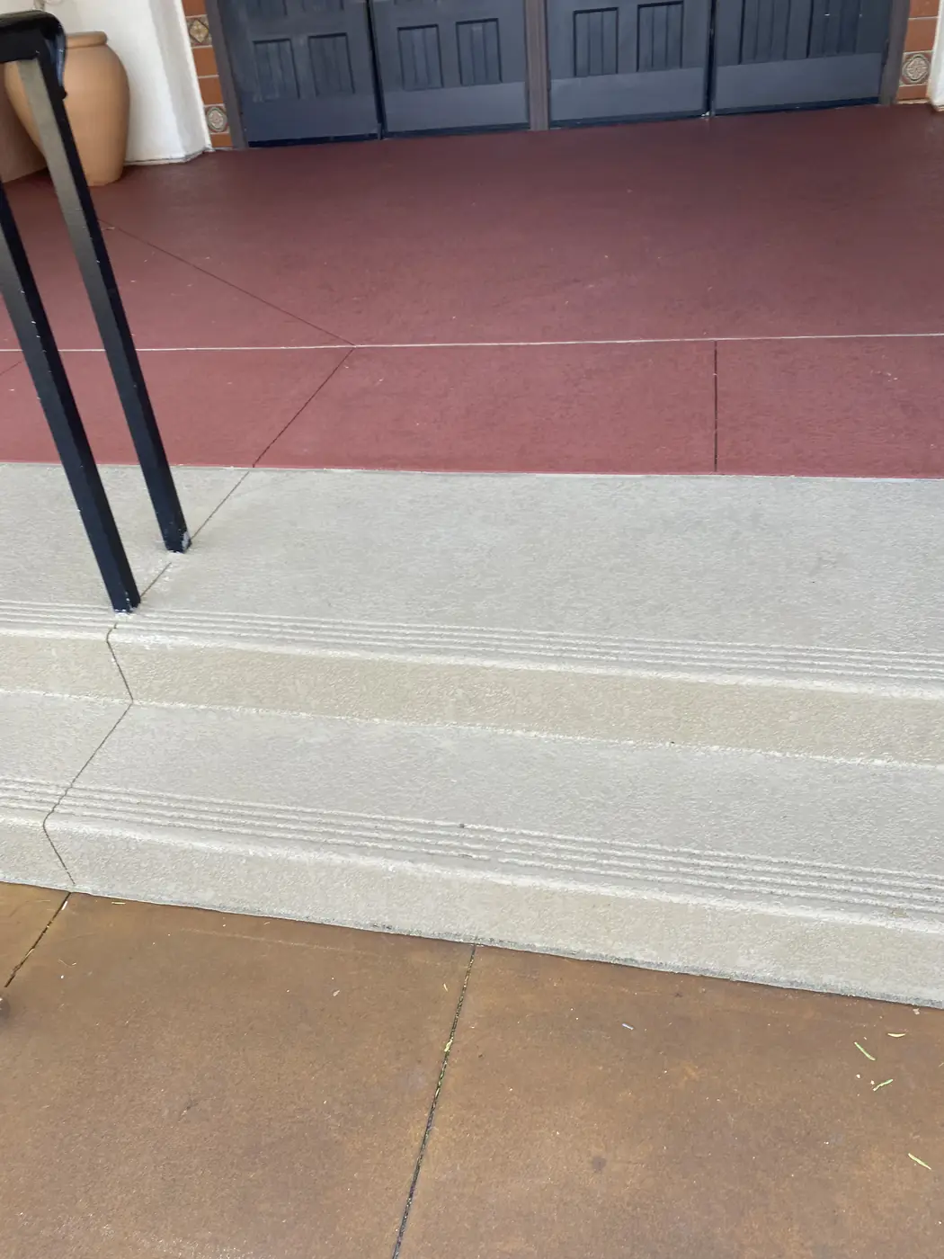Resurfaced steps in cream with grooved treads and a red walkway beyond