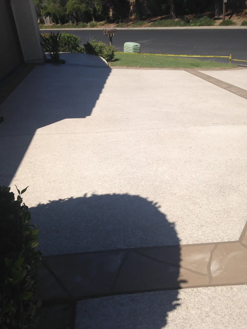 Cream resurfaced patio with a contrasting border in low sunlight