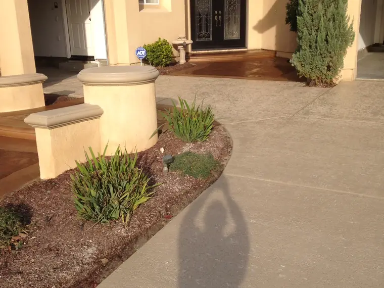 Resurfaced tan entry walkway leading to a residential front door