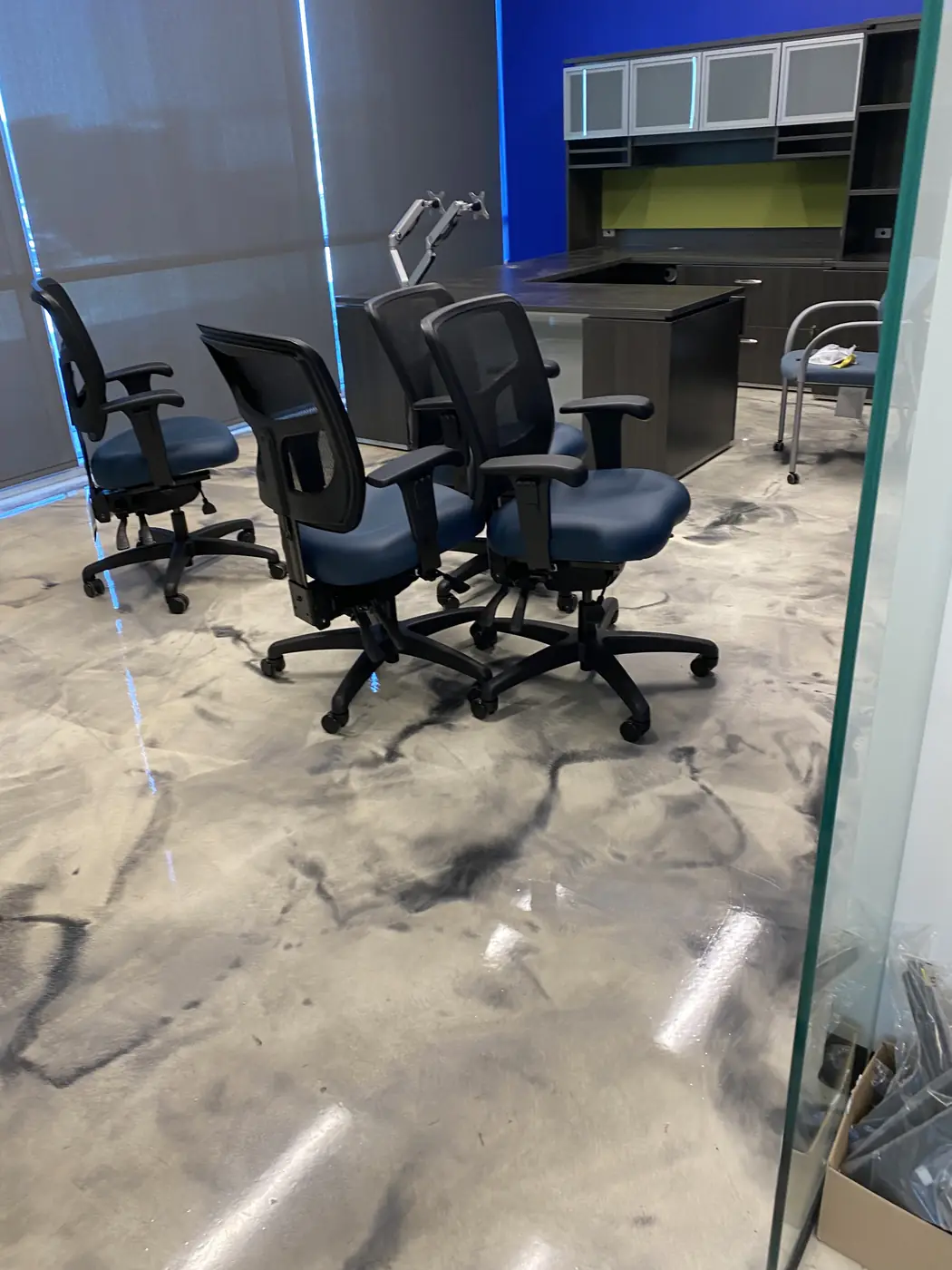 Office chairs standing on a swirled gray and white metallic epoxy floor