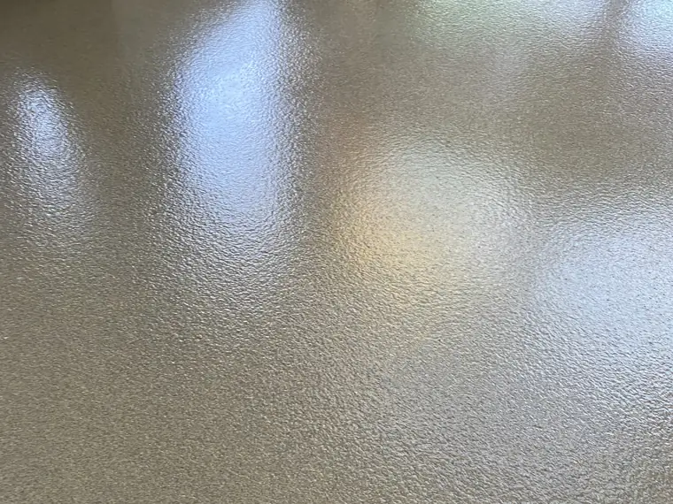 Gray flake epoxy floor with a timber pallet resting at the edge