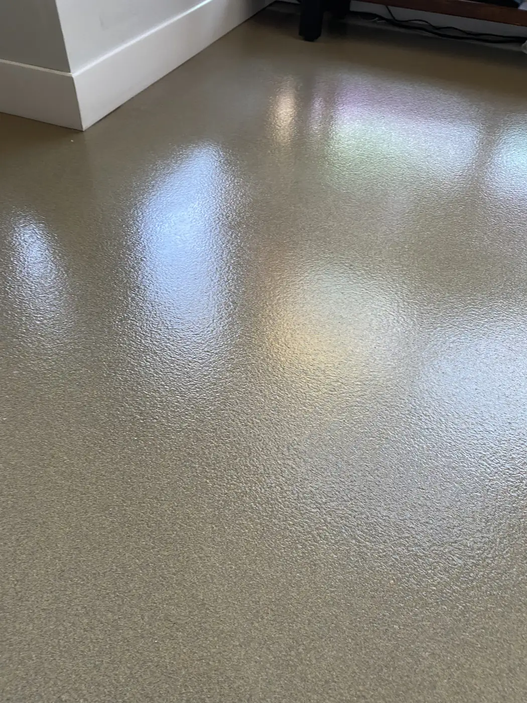 Gray flake epoxy floor with a timber pallet resting at the edge