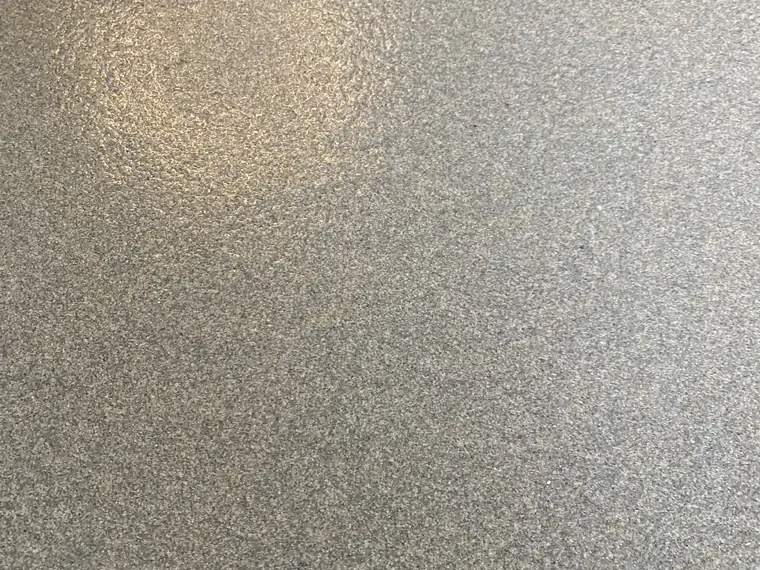 Close view of gray and black flake broadcast into a clear epoxy topcoat