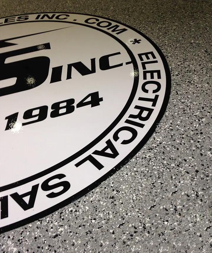 Company crest inlaid into speckled gray flake epoxy at floor level