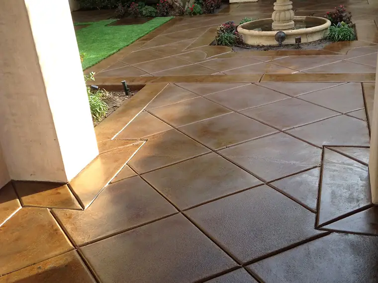 Stained courtyard in a large tile pattern around a stone fountain
