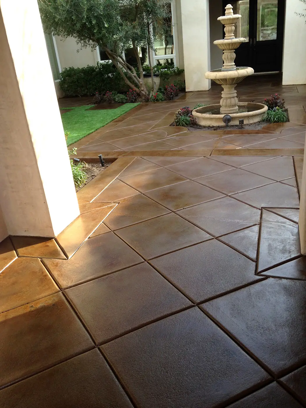 Stained courtyard in a large tile pattern around a stone fountain