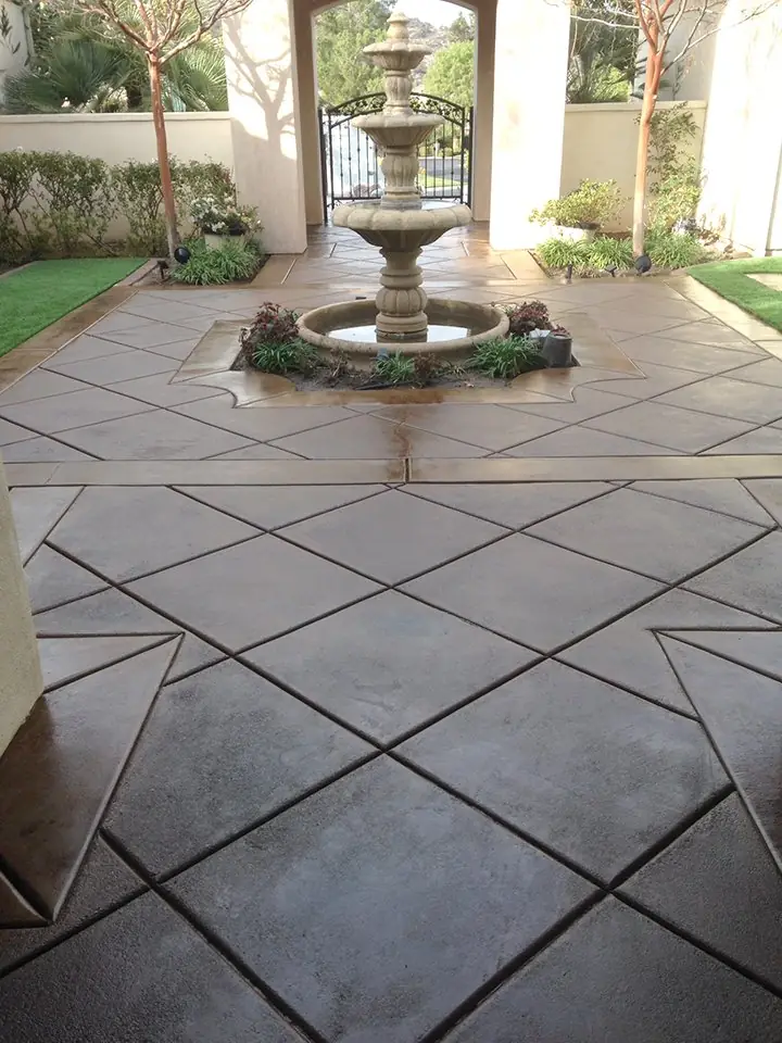 Diamond-scored stained courtyard leading to a tiled fountain