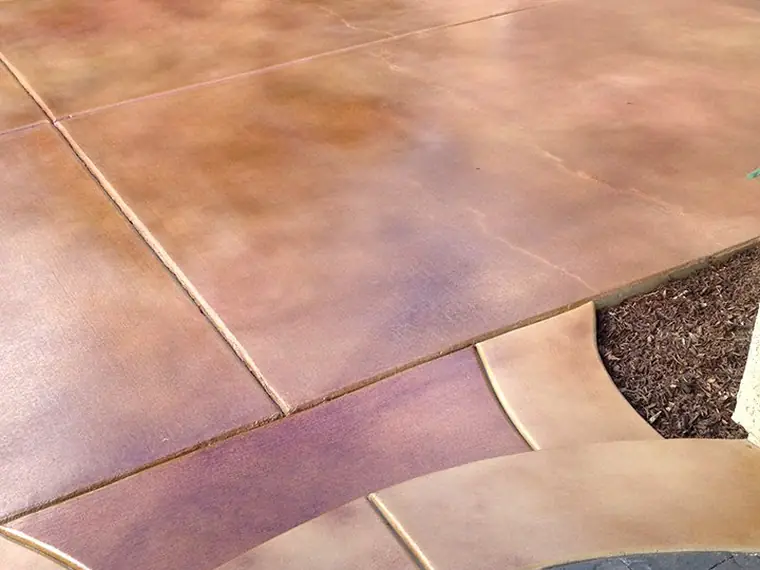 Mauve stained driveway edged with a contrasting paver border