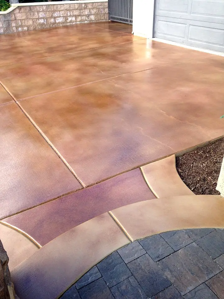 Mauve stained driveway edged with a contrasting paver border