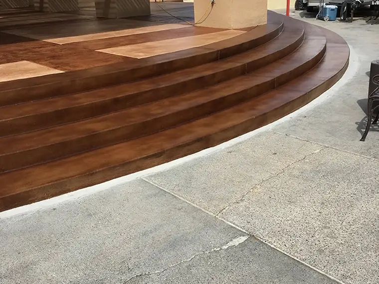 Curved entry steps stained to a wood-plank look