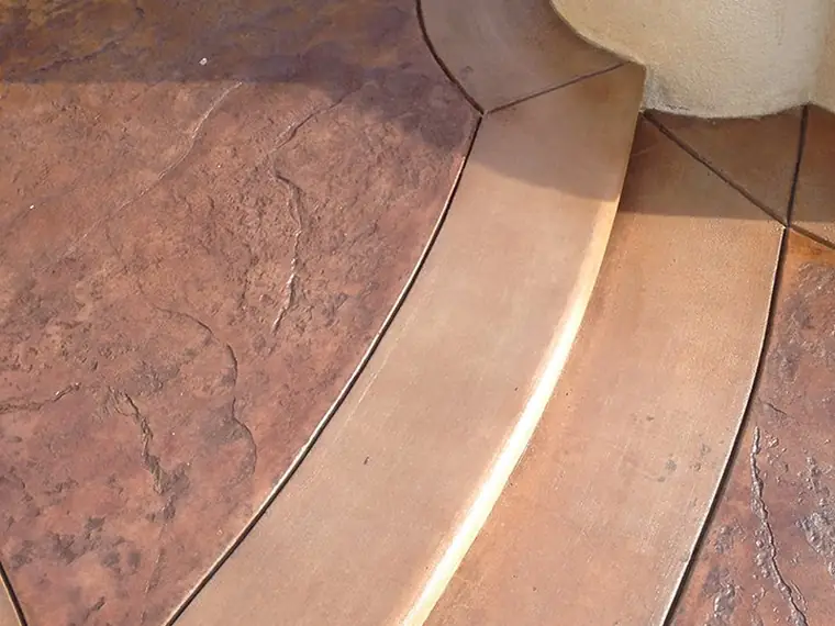 Curved stained patio with a textured contrasting border