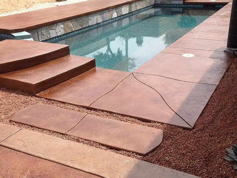 Red stained pool deck and steps set in a red rock landscape