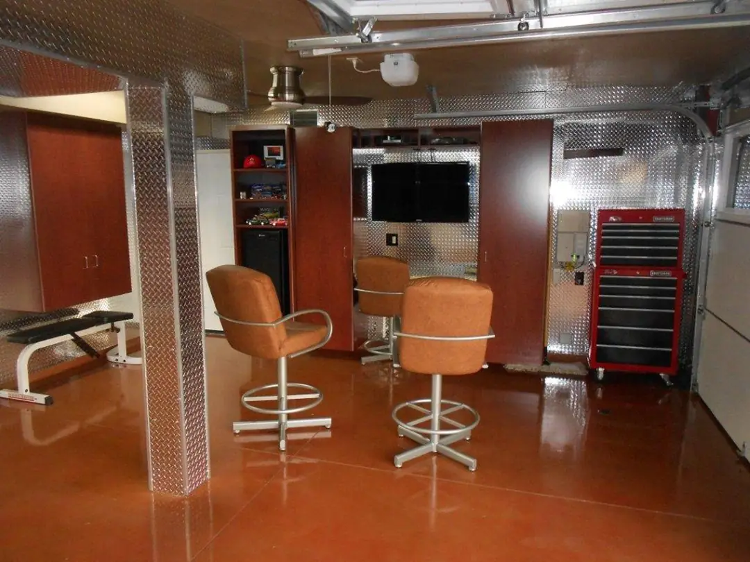 Home workshop garage with a copper-stained floor, bar stools and a red tool chest