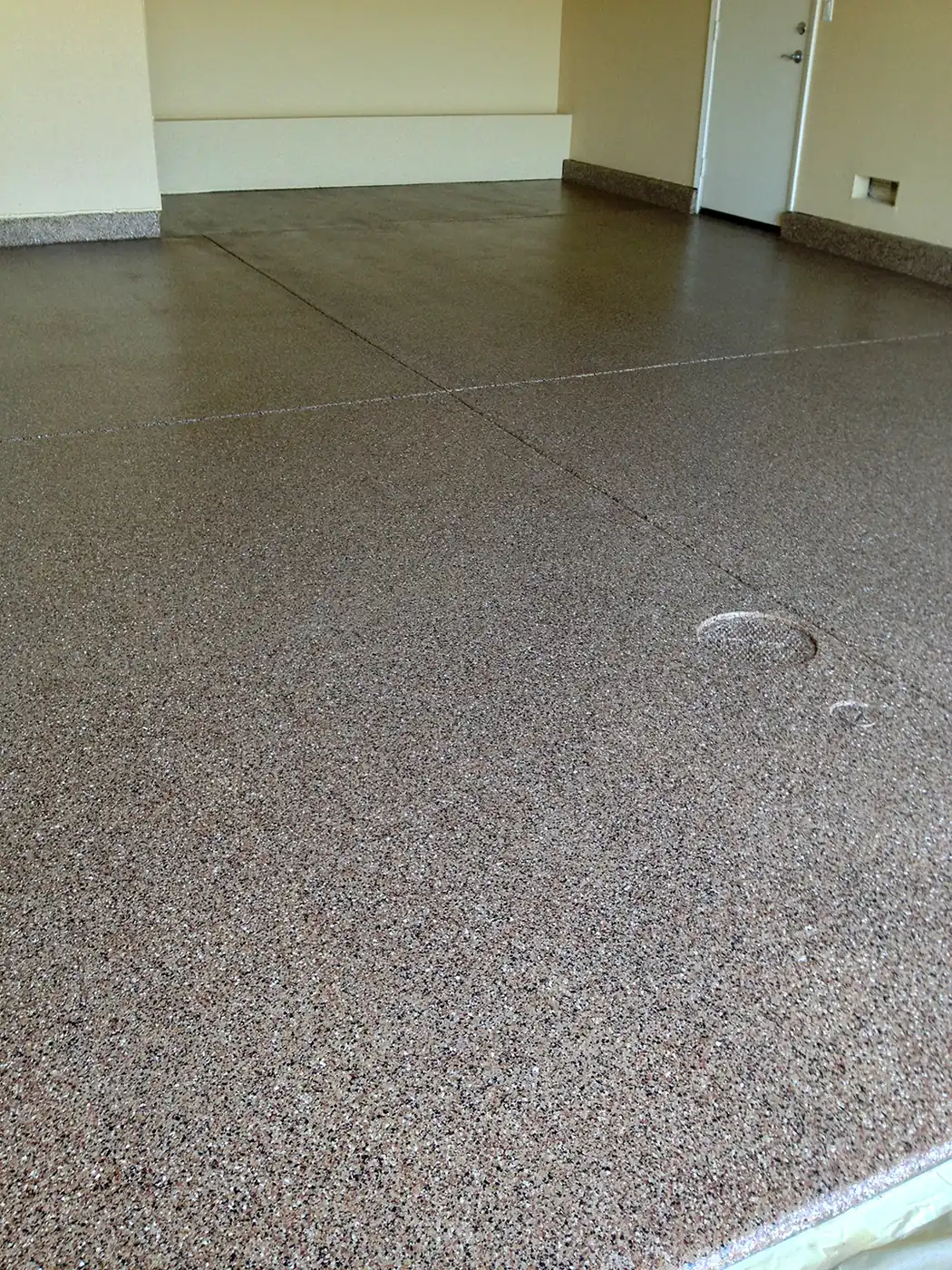 Gray flake epoxy garage floor with a coved edge along the wall
