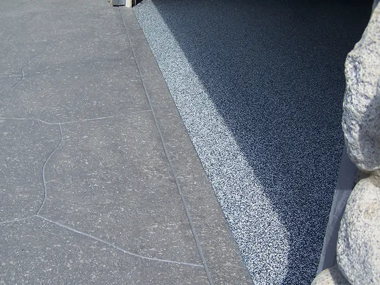 Blue and gray flake epoxy meeting a clean coved edge in a garage