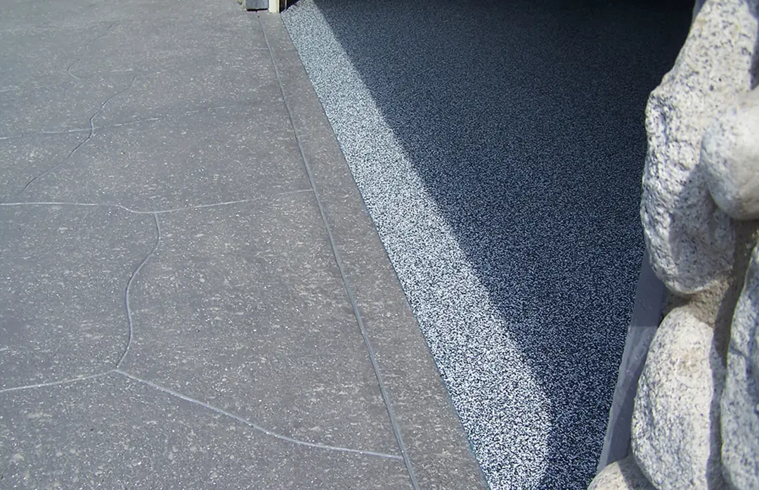 Blue and gray flake epoxy meeting a clean coved edge in a garage