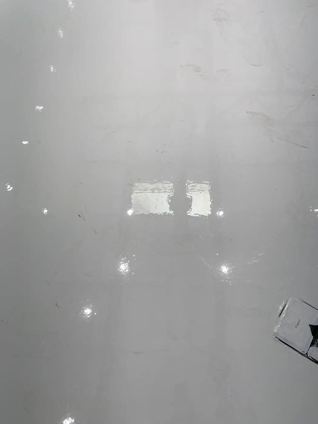 Gray epoxy floor with the old patch lines still visible through the gloss