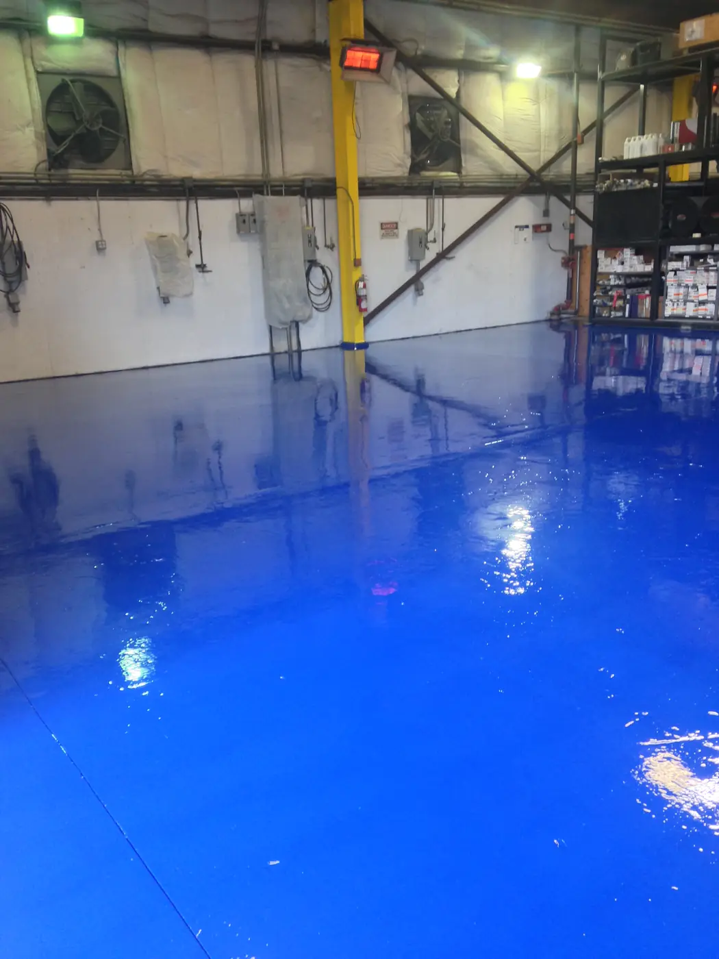 Glossy blue epoxy floor reflecting the plant lighting overhead