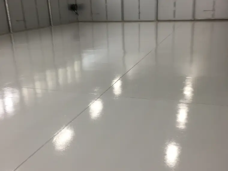 White high-gloss epoxy floor in a clean industrial bay