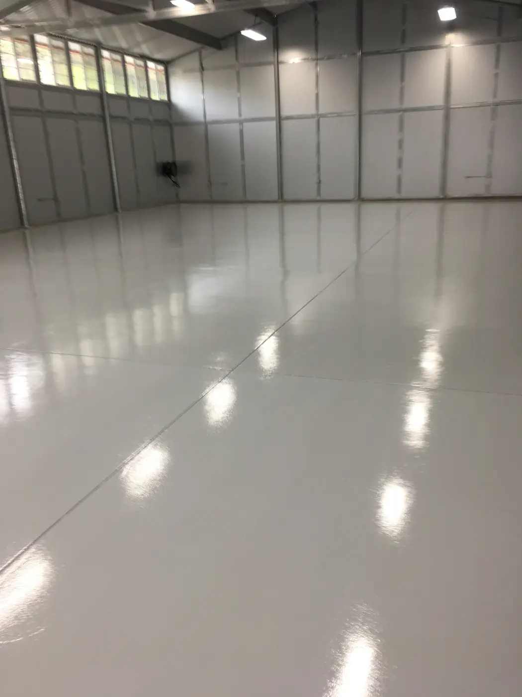 White high-gloss epoxy floor in a clean industrial bay