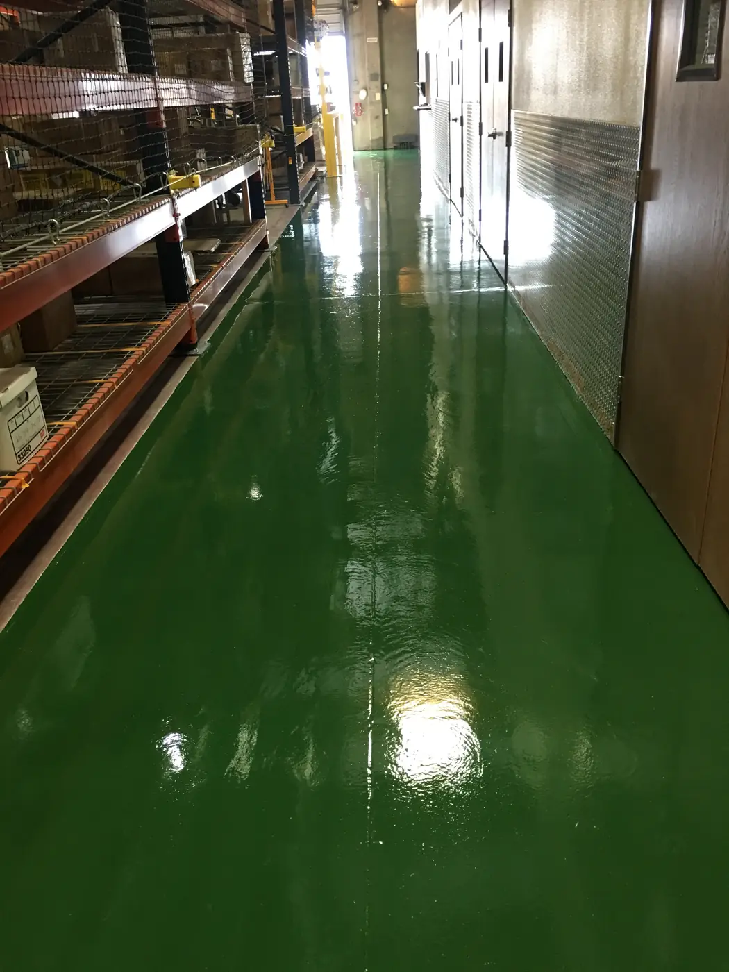 Dark green epoxy aisle running between warehouse racking