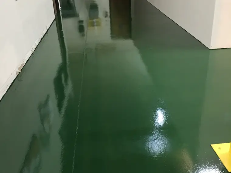 Glossy dark green epoxy corridor between white warehouse walls