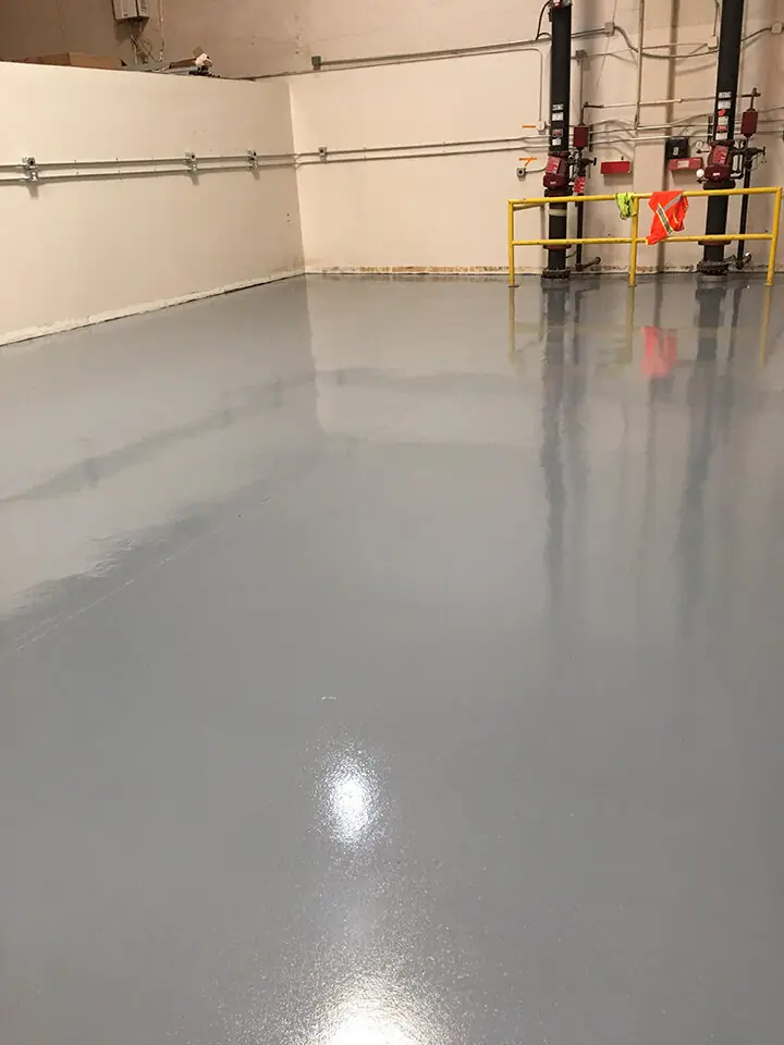 Gray epoxy floor stretching through an empty warehouse