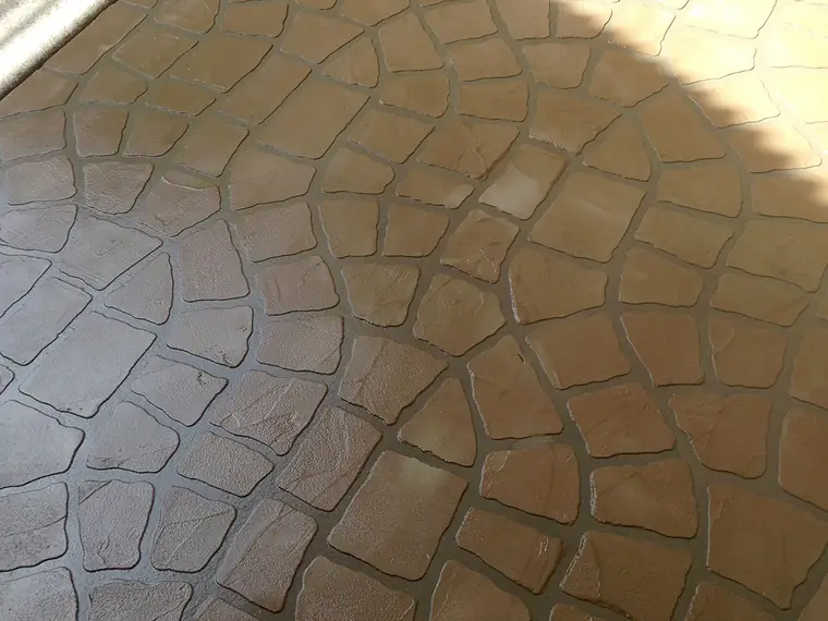 Cobblestone-pattern overlay stamped into a patio in warm brown