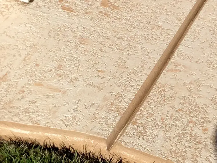Light tan microtopping meeting a lawn edge with a contrasting border