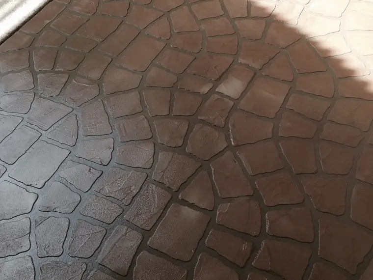 Brown stamped concrete overlay in a rounded cobblestone pattern