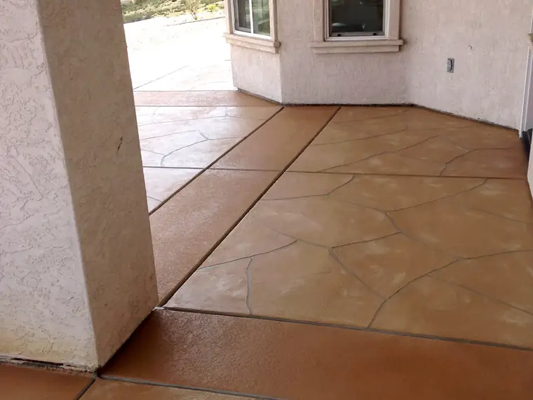 Terracotta stamped overlay patio running along the side of a house
