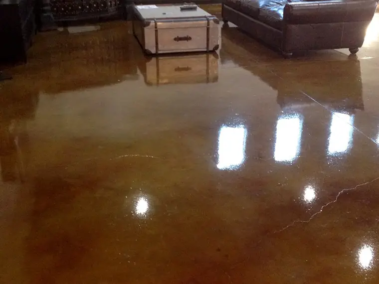High-gloss copper stained concrete floor in a living room with leather seating