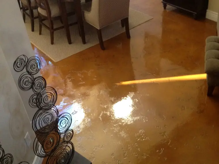 Copper stained concrete floor in a dining room with timber furniture