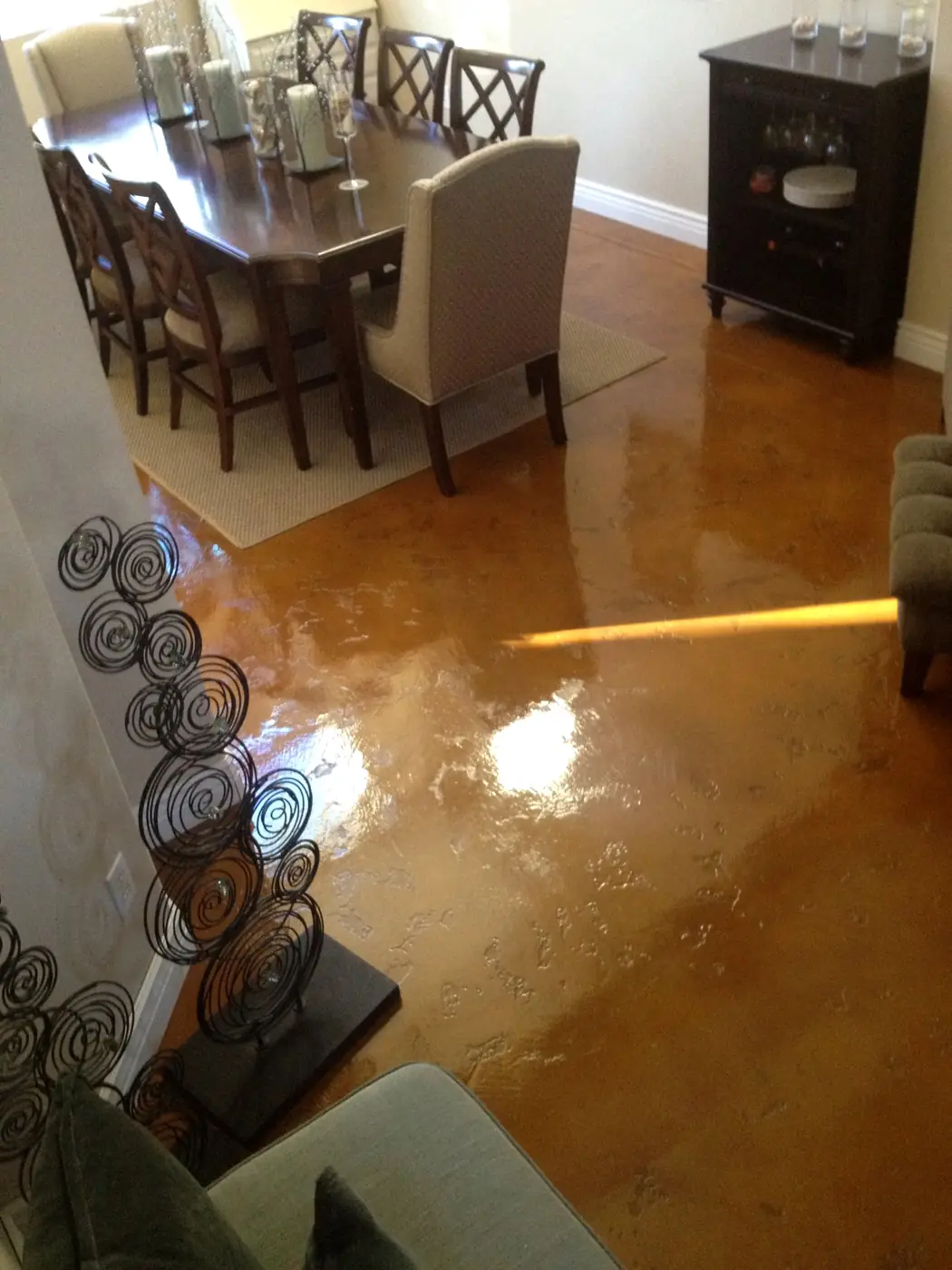 Copper stained concrete floor in a dining room with timber furniture