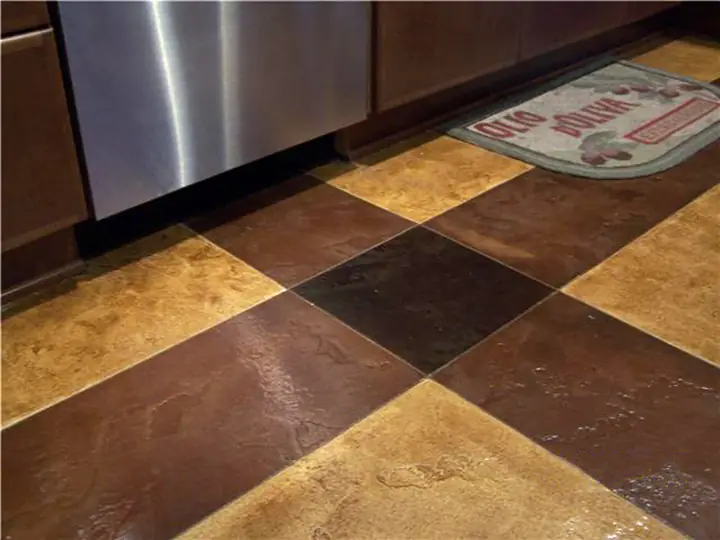 Checcurboard stained concrete floor in gold and dark brown at a kitchen bench
