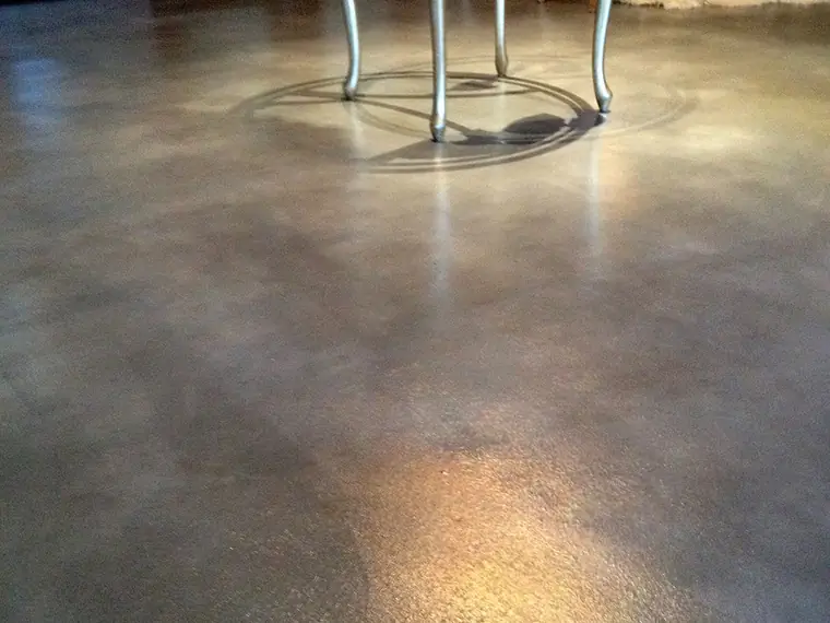 Gray and tan stained concrete entry floor with a dining table