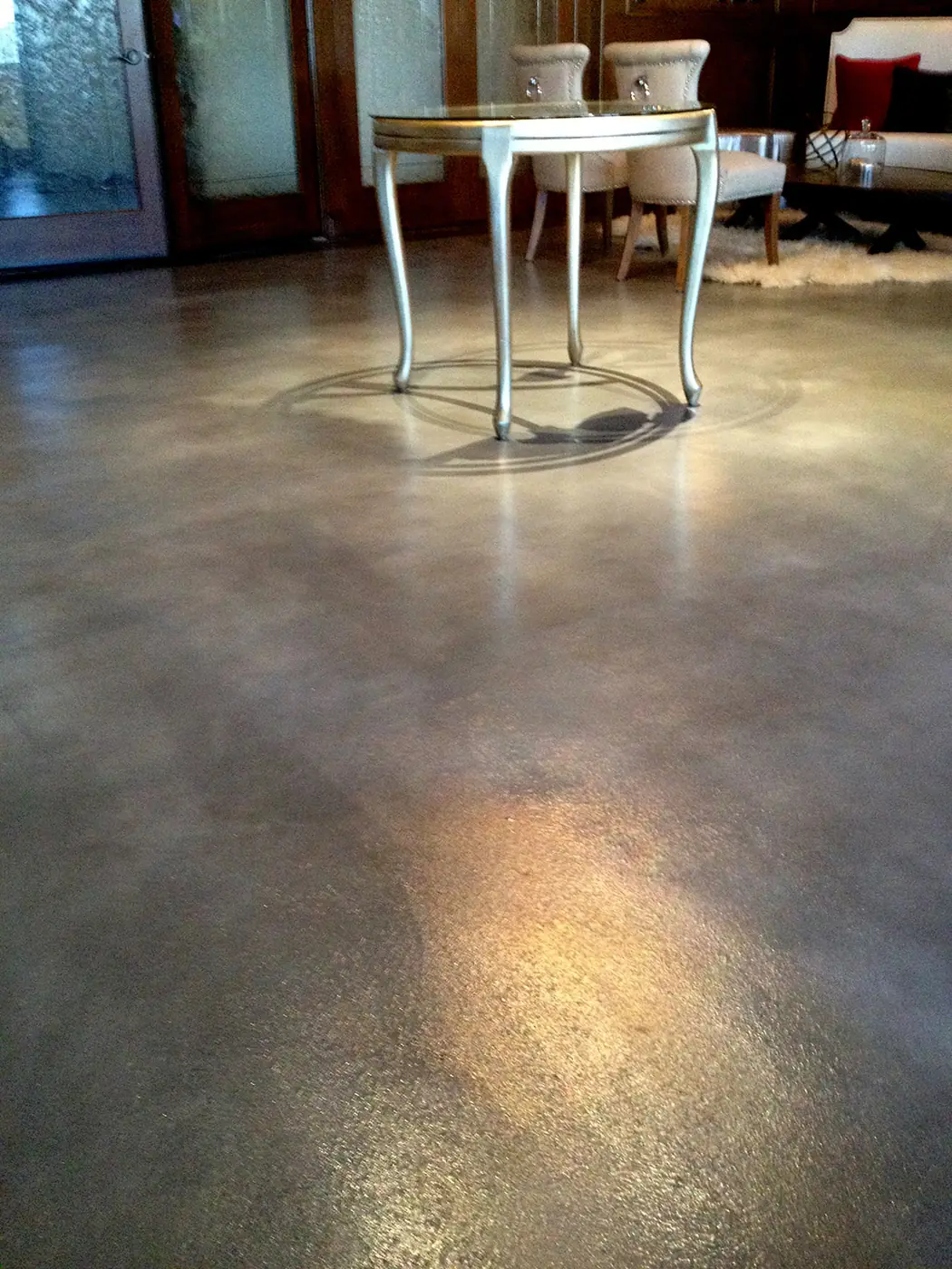 Gray and tan stained concrete entry floor with a dining table