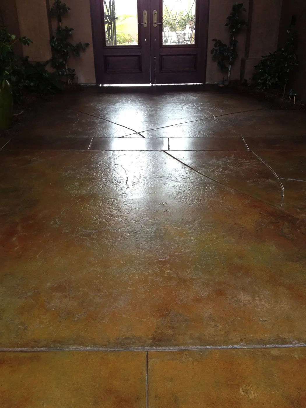 Mottled tan stained entry floor with score lines and double doors