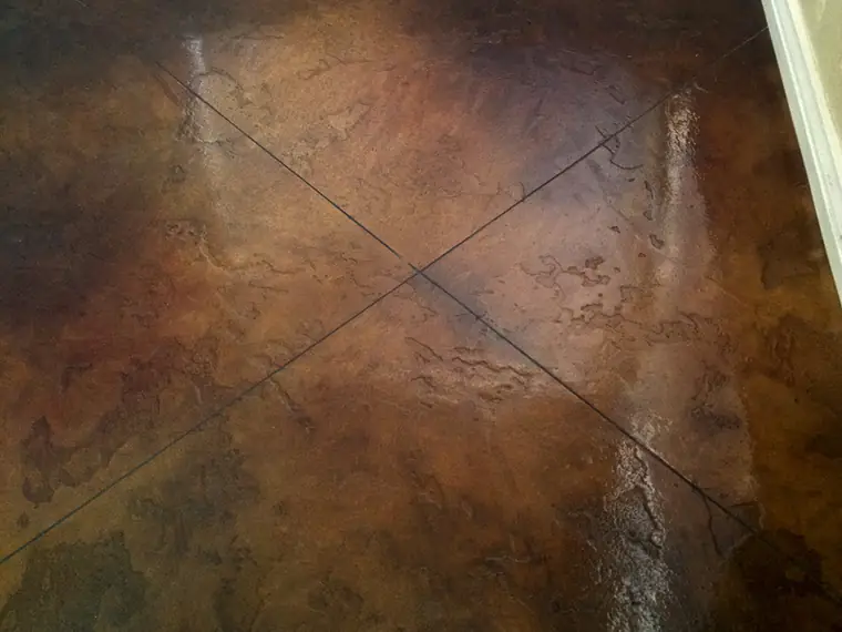 Dark brown stained concrete floor scored in a diamond pattern
