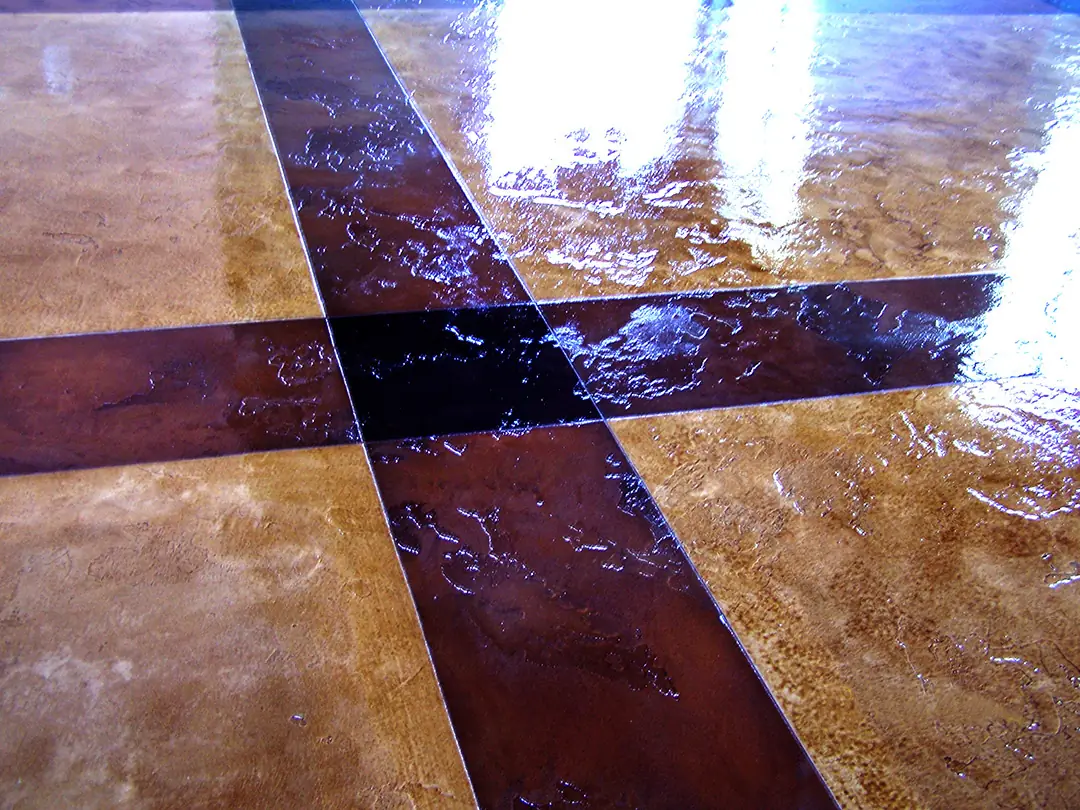 Stained concrete floor with a dark cross inlay running through it