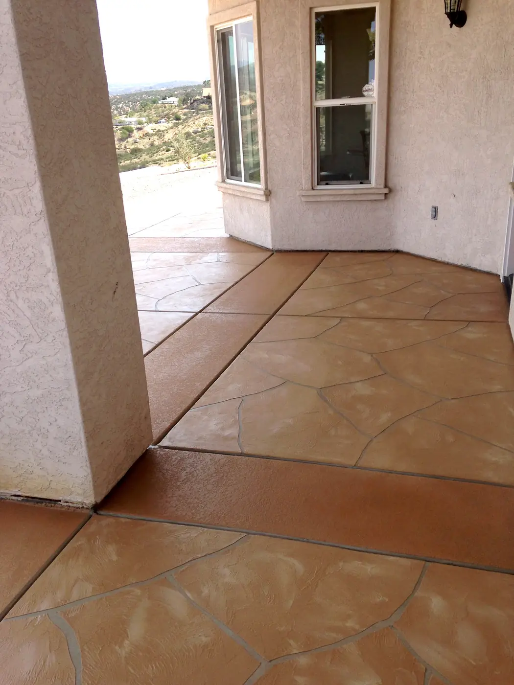 Terracotta stained floor scored in a tile pattern beside a window