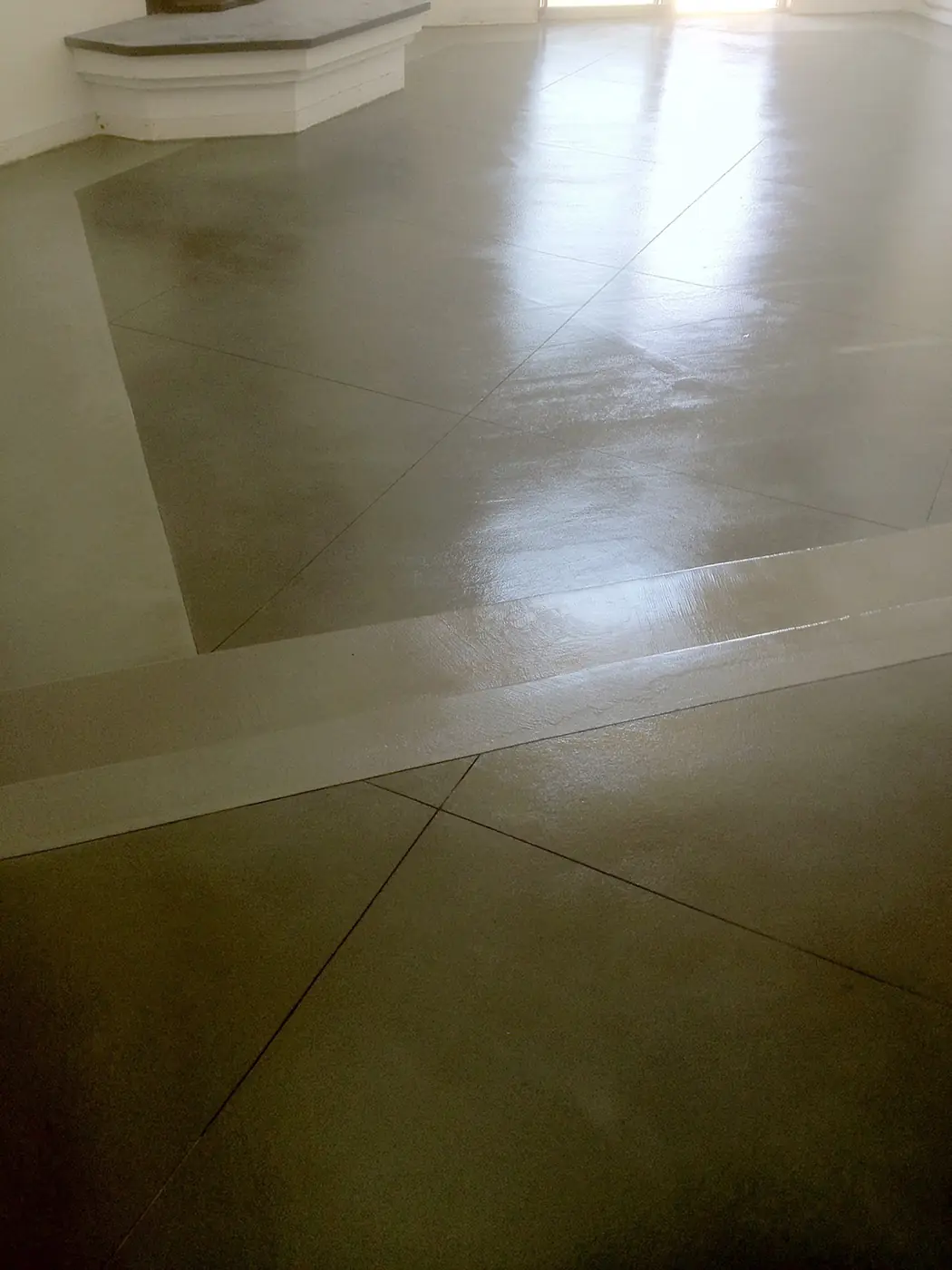 Polished tan concrete floor with a lighter inset border
