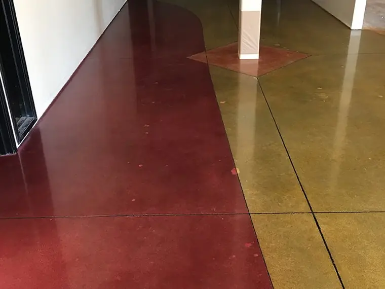 Red and gold stained concrete hallway floor with a curved color break