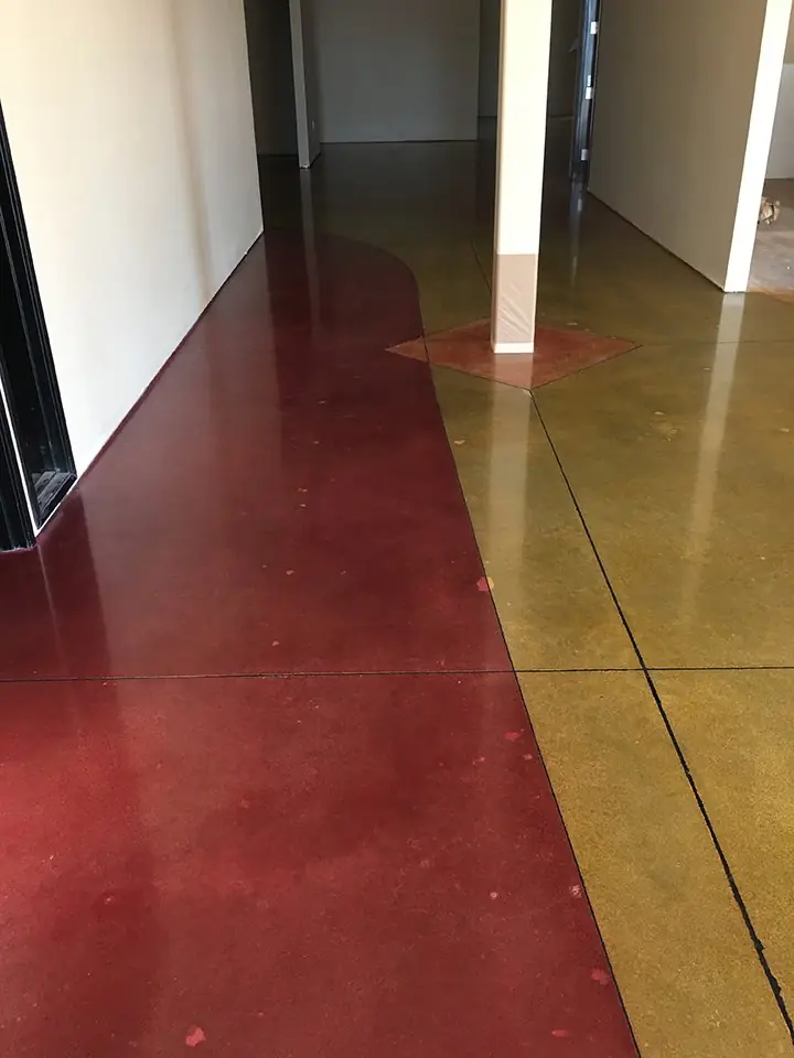 Red and gold stained concrete hallway floor with a curved color break