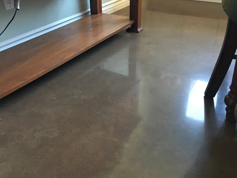 Polished brown concrete floor beneath a timber console table