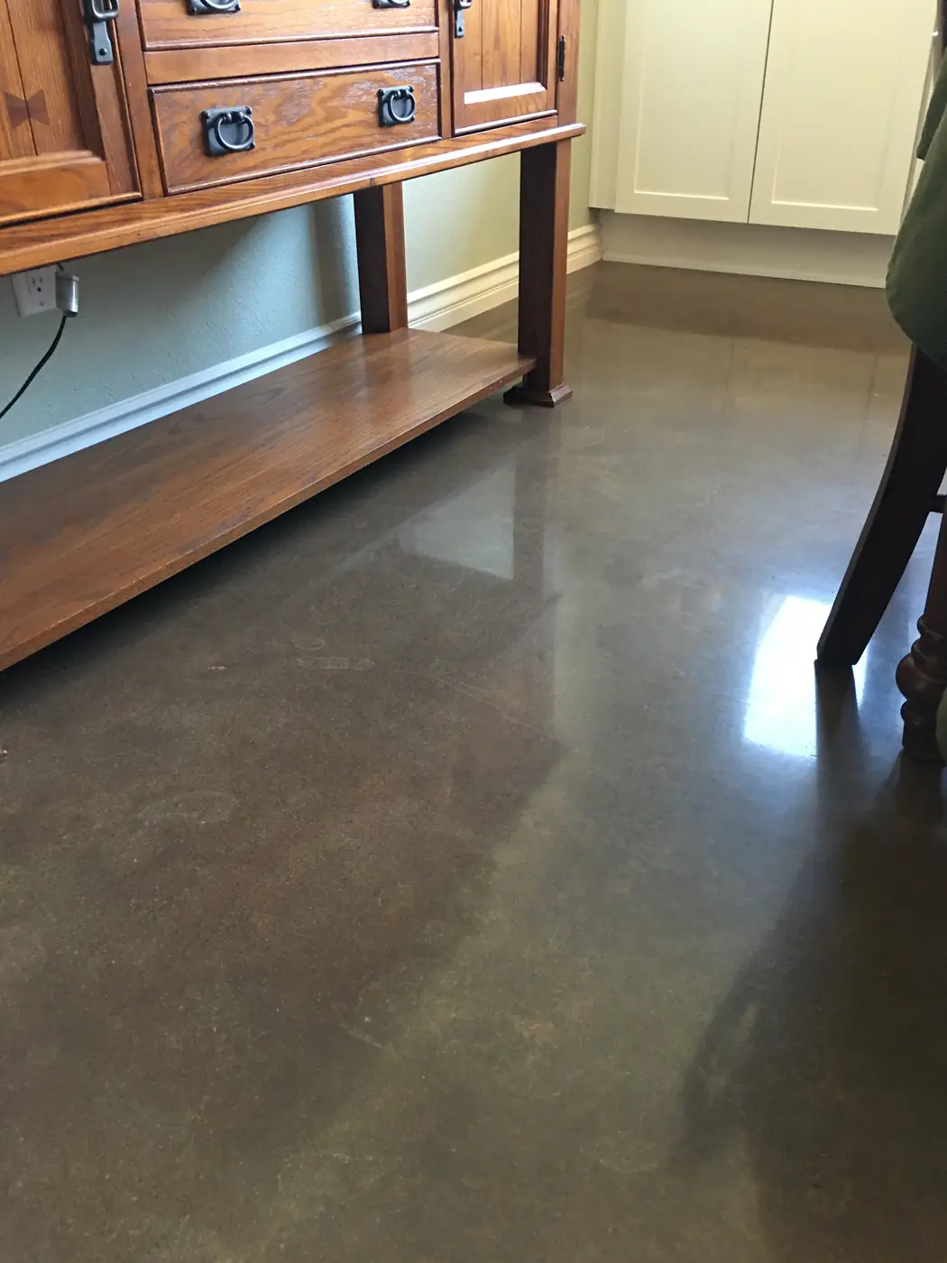 Polished brown concrete floor beneath a timber console table